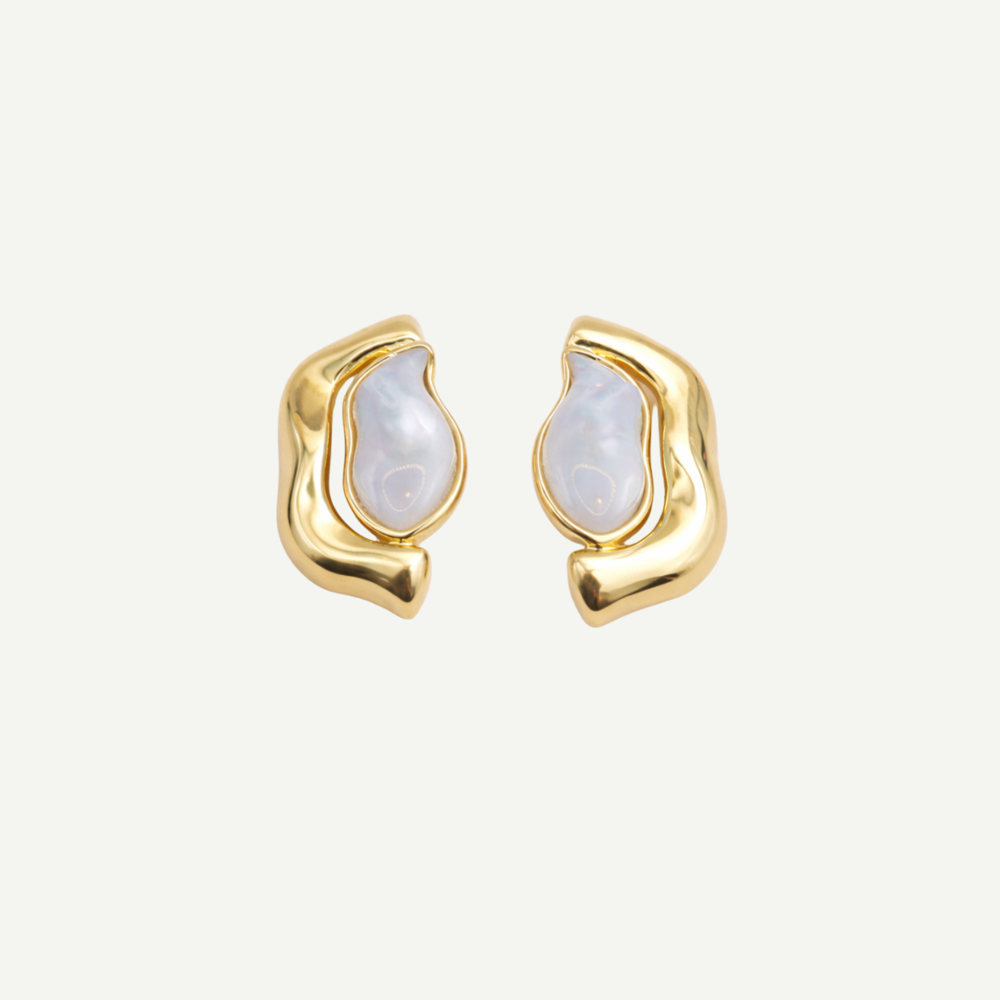 Gold earrings with nacre gemstone on a light beige background