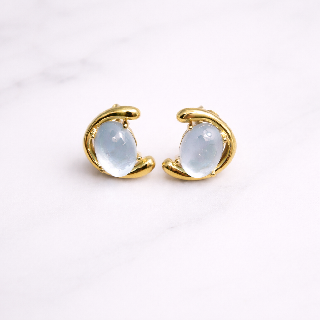 Gold hoop earrings with a nacre gemstones on a white background
