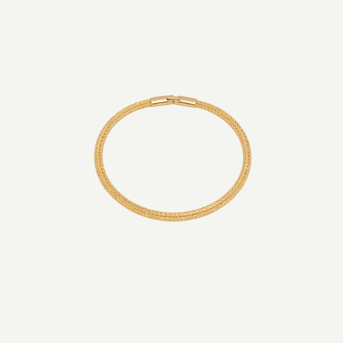 Gold bracelet on a light beige background