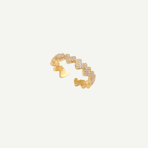 Gold ring with heart-shaped design on a light gray background
