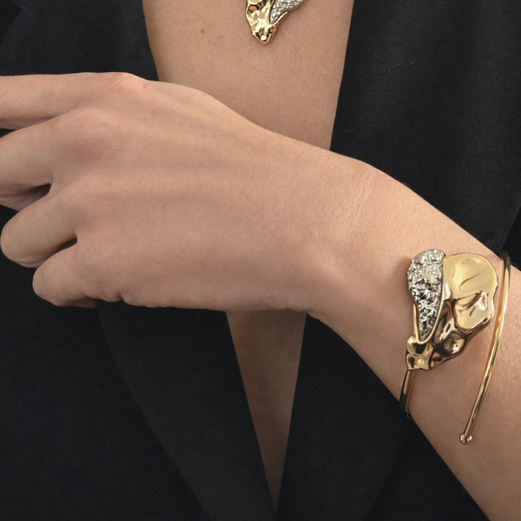 Gold leaf-shaped bracelet on a wrist 