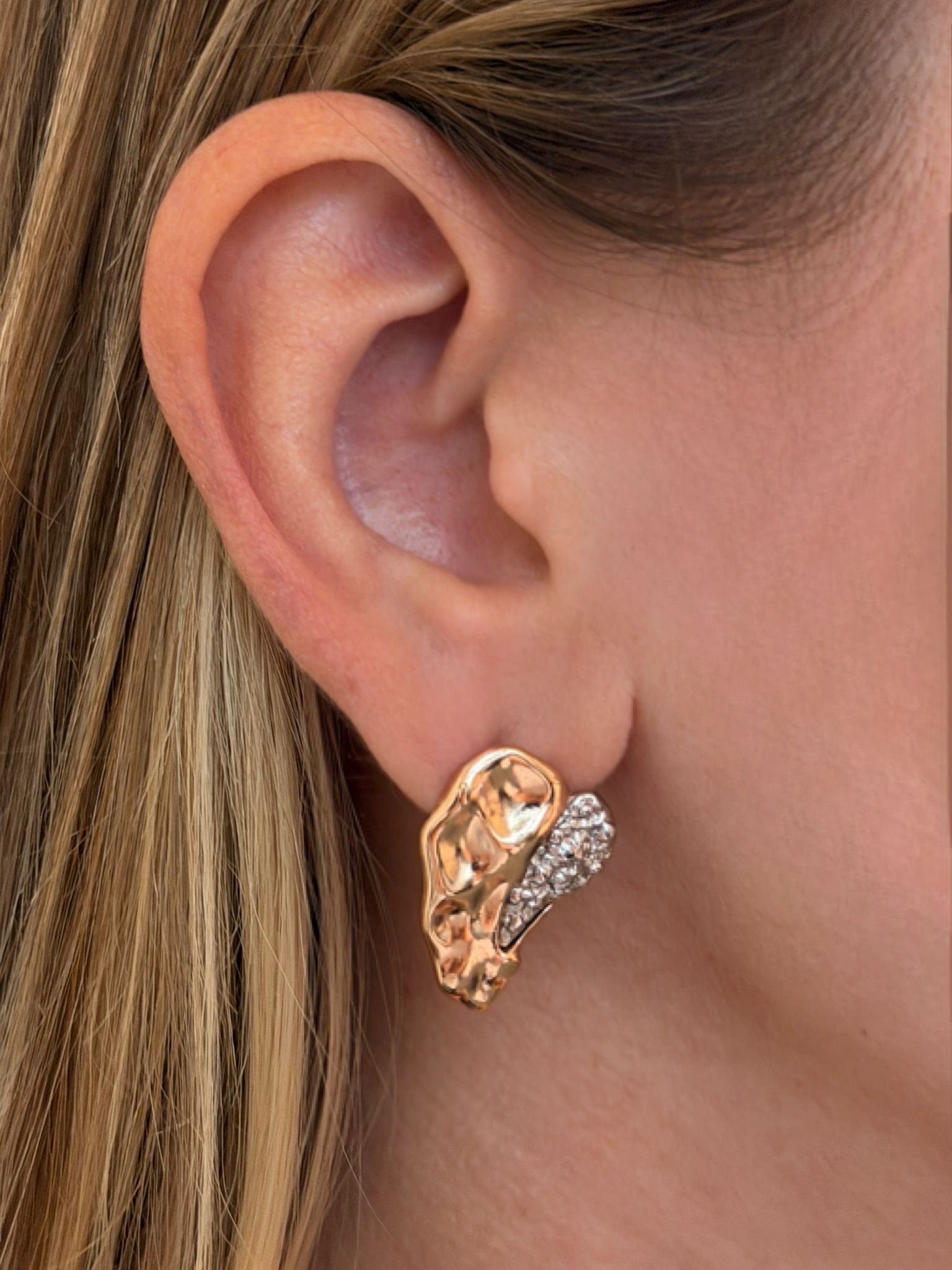 Close-up of a person wearing a gold earring
