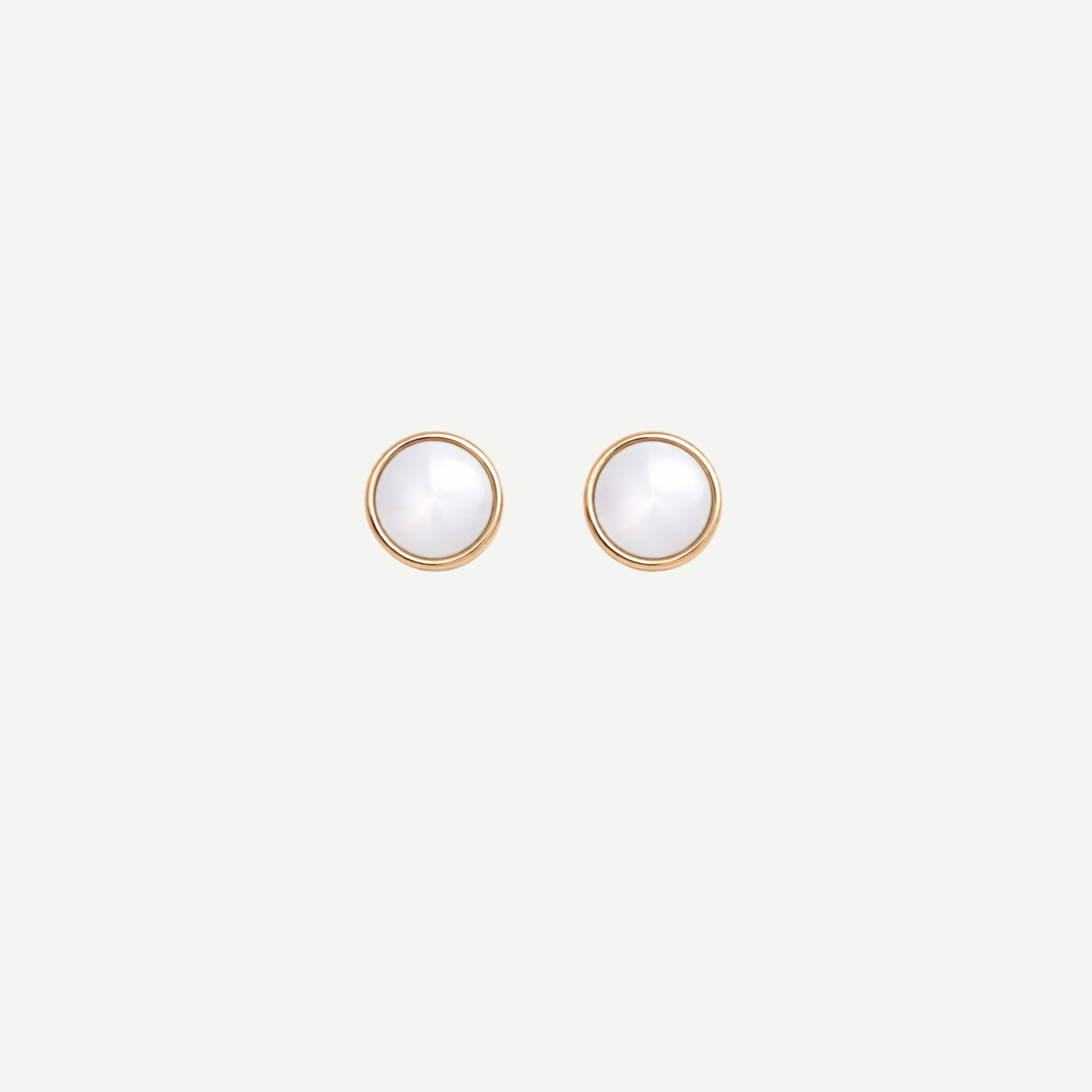 Pair of gold earrings with nacre gemstones on a light gray background