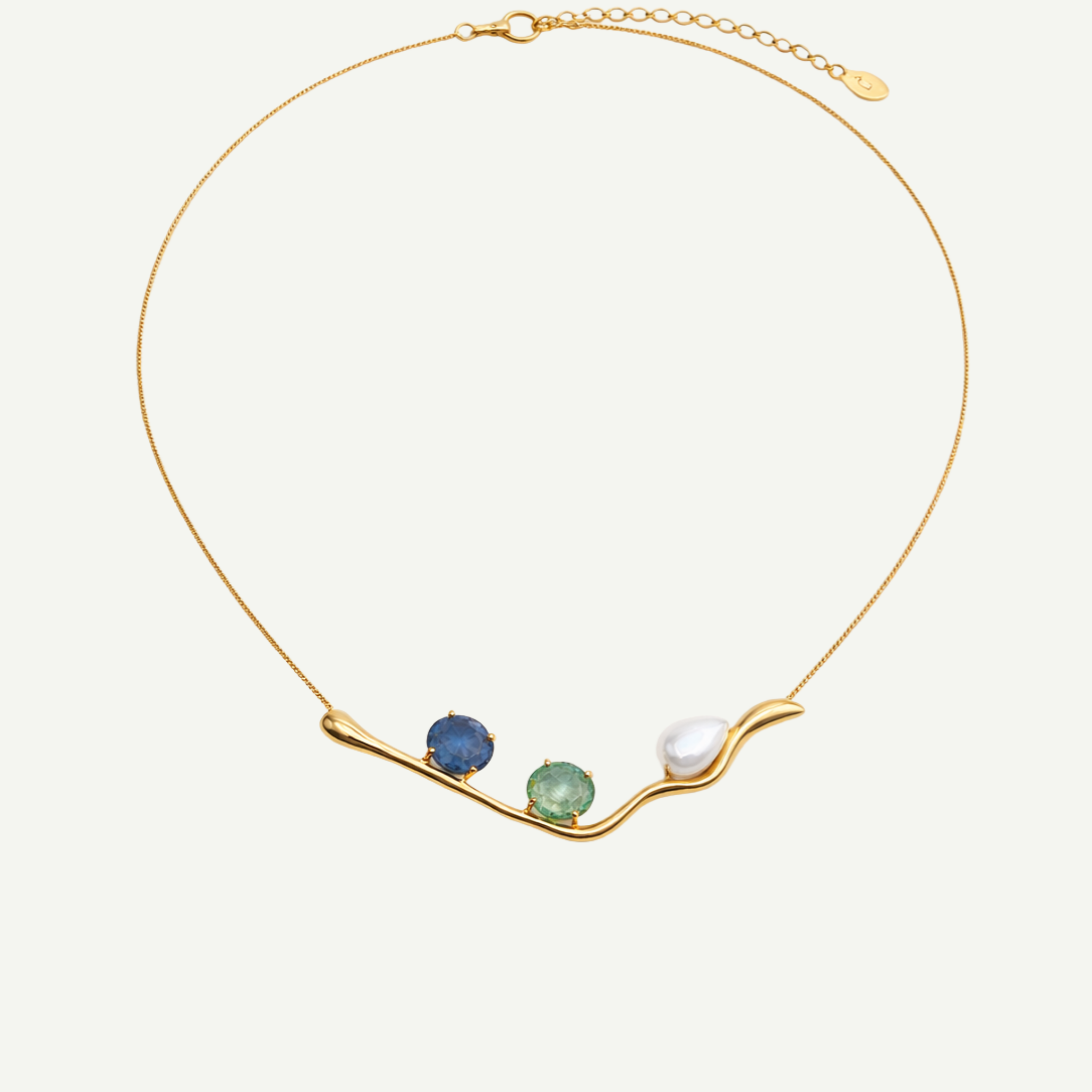 Gold necklace with three gemstones on a white background