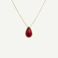 Gold necklace with a natural agate red teardrop pendant on a white background
