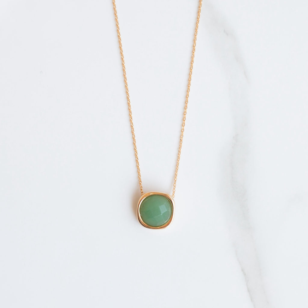 Necklace with a natural green quartz stone pendant on a white background