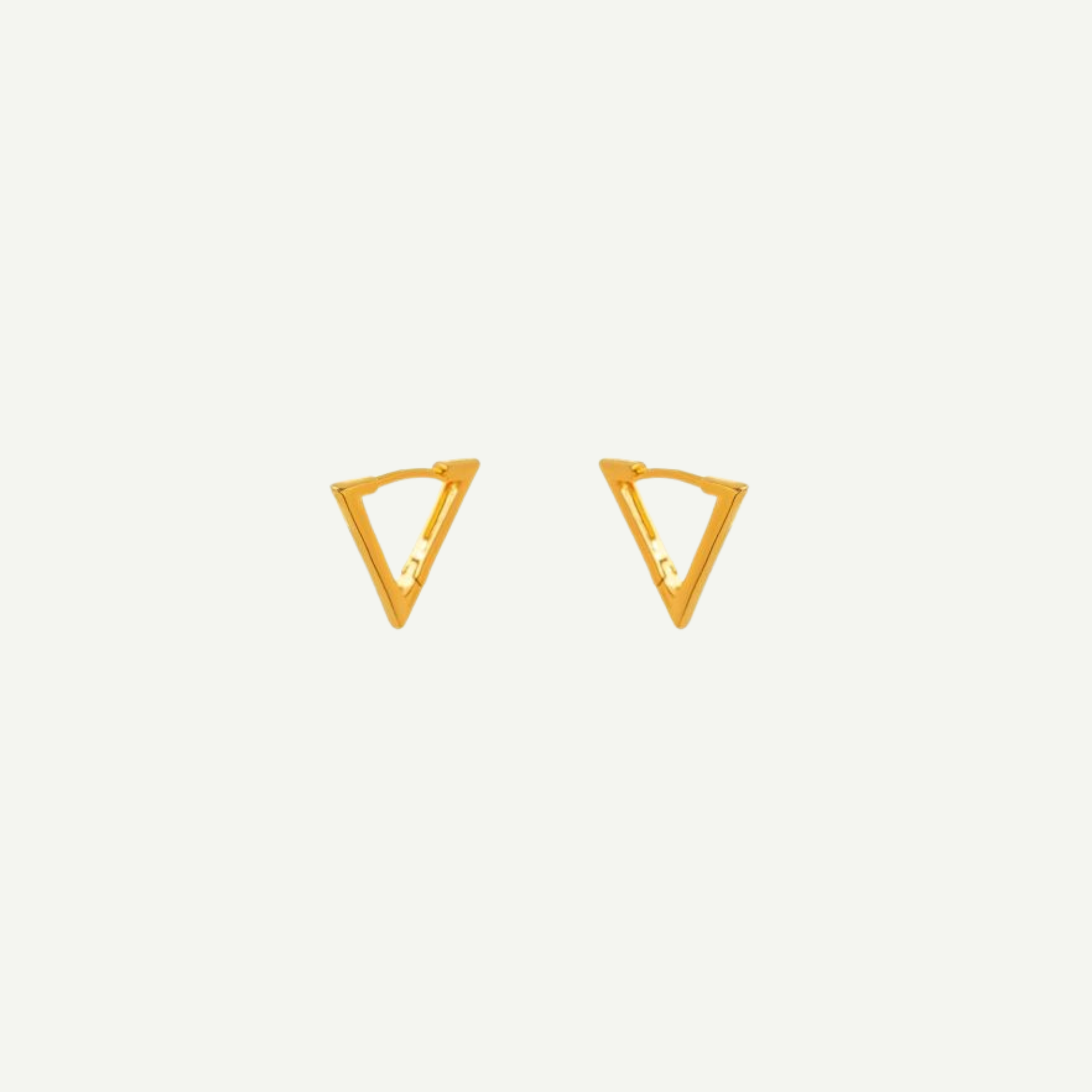 Gold triangle-shaped earrings on a light gray background