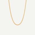 Gold chain necklace on a light gray background
