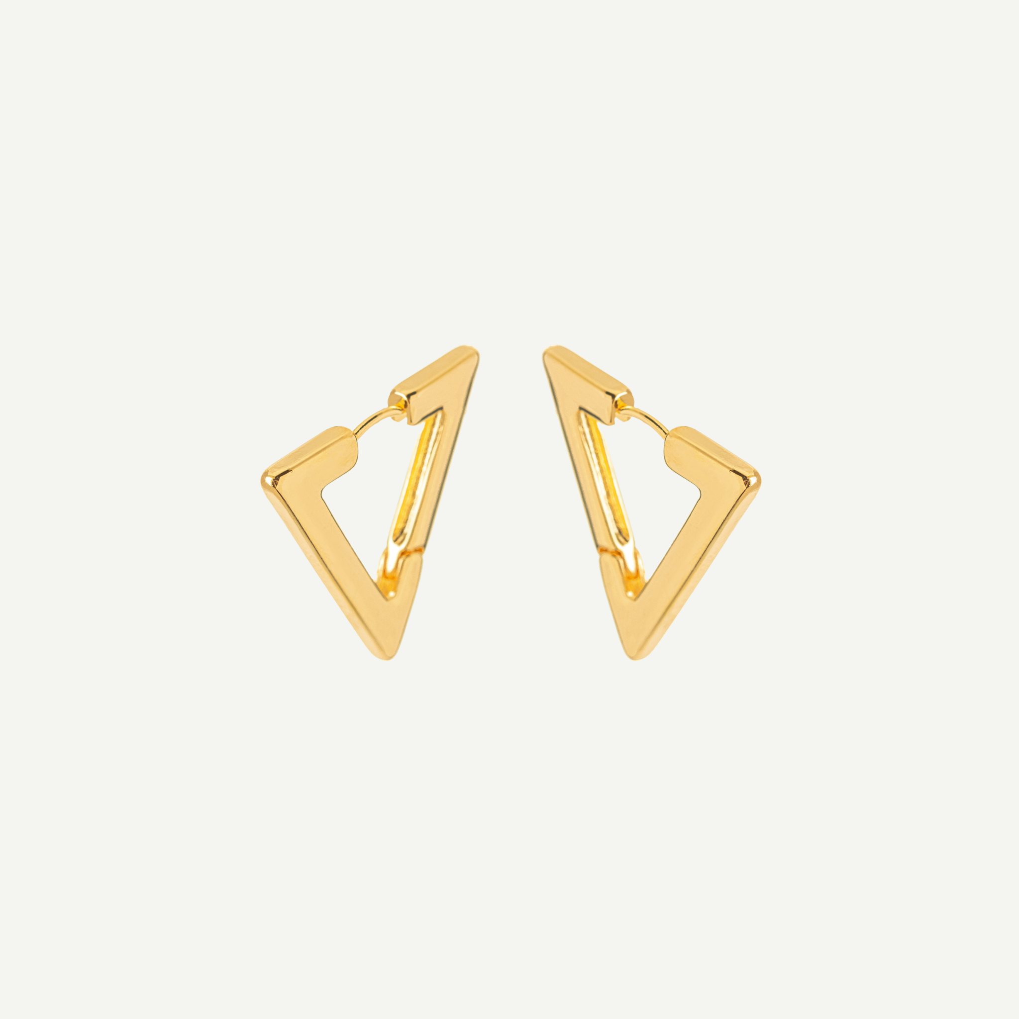 Gold triangle-shaped earrings on a light gray background
