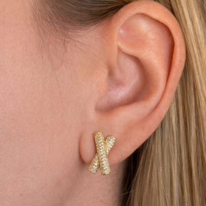 Gold Valentina X earrings worn by a person with blonde hair.