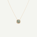 Necklace with a green pendant on a light beige background