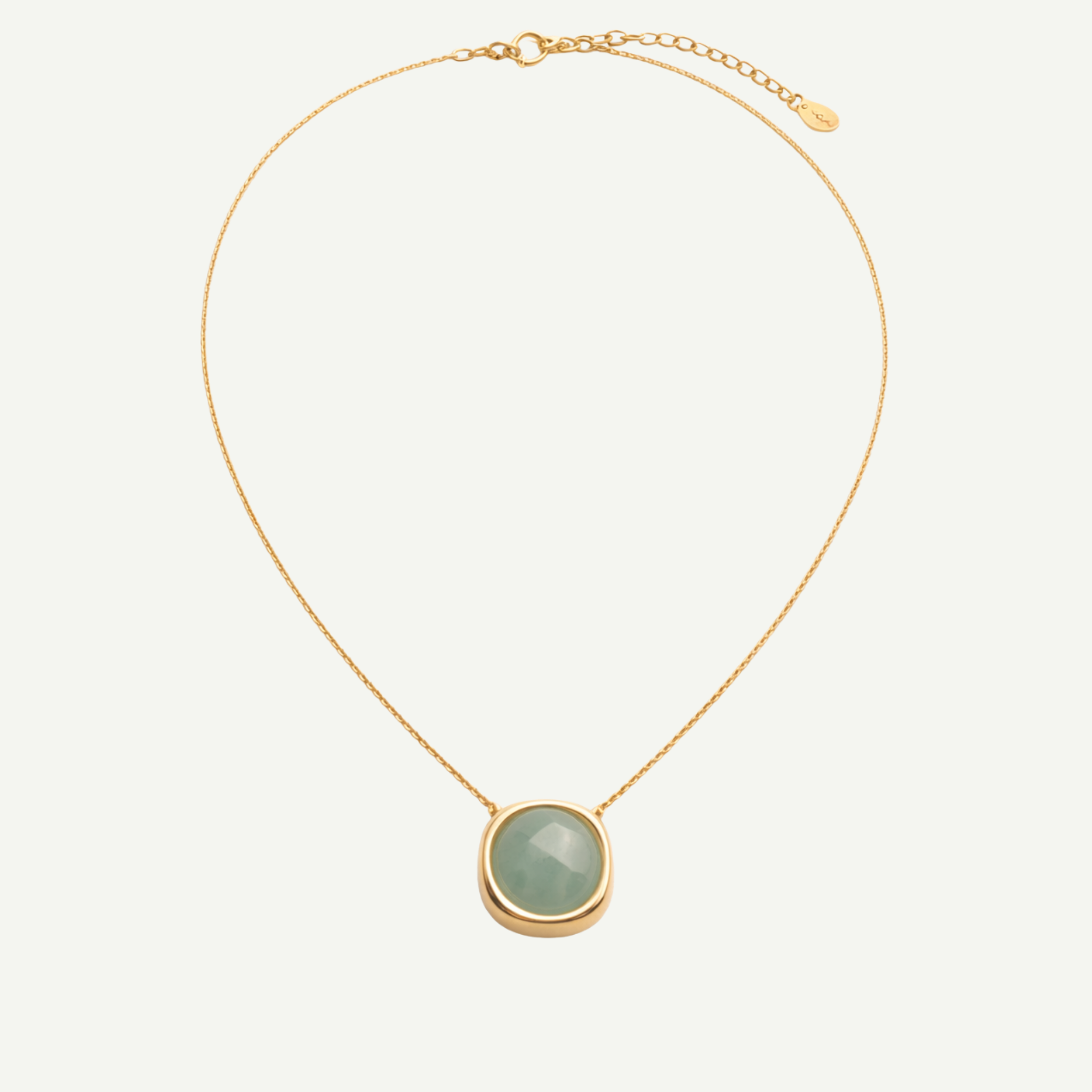 Gold necklace with a green pendant on a white background