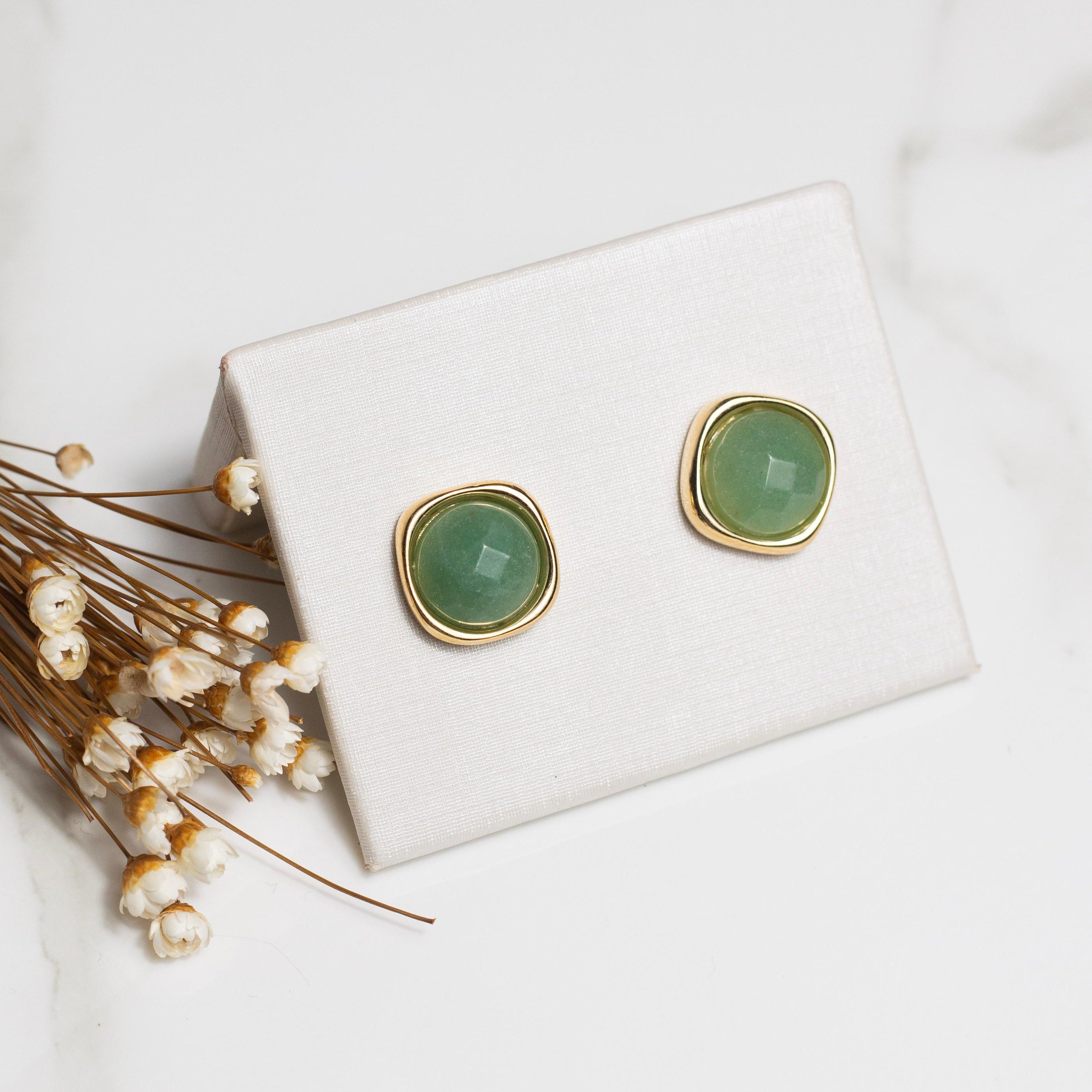 Green quartz earrings on a white card with a white background